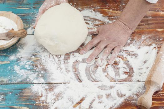 Hands of a baker kneading dough.