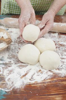 Fresh pizza dough, rolled into round balls, covered in white flour. Ready to Bake Pizza Dough