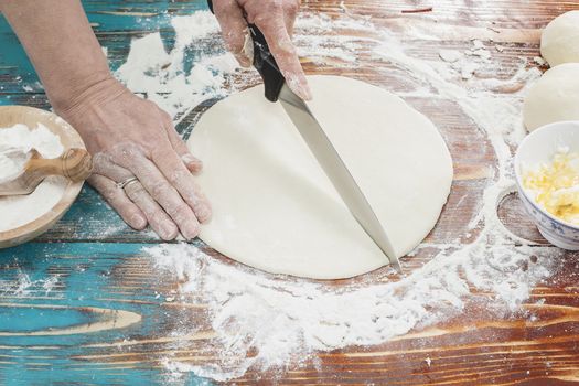 Cutting Dough for Croissants on Rustic Wood Table