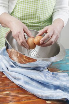 Woman hands breaking the egg over a bowl