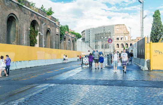 ROME - MAY 18, 2014: Tourists walk near Colosseum. More than 15 million people visit the city every year.