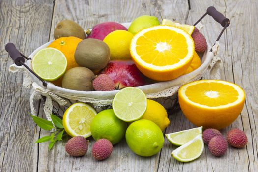 fresh fruits in a basket on wooden background