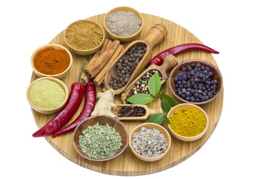 Variety of spices on wooden board, isolated on white