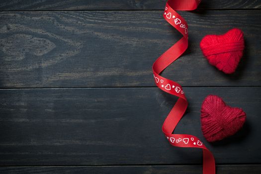 Red hearts made of wool on wooden background for Valentine's Day. Copy space. Top view