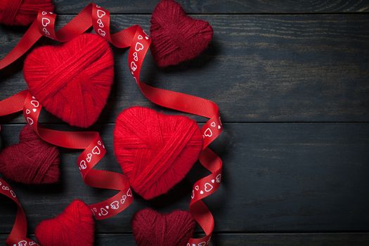 Red hearts made of wool on wooden background for Valentine's Day. Copy space. Top view