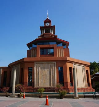 Octagonal clock tower brown color is in university of Thailand.