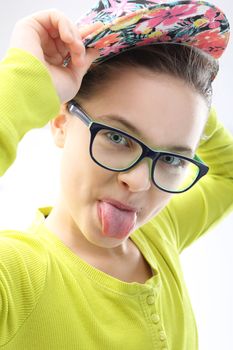 Portrait of girl in colorful clothes and cap doing funny faces