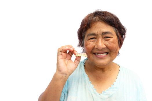 Old aged thai woman smile and hold denture. And blank area at left side
