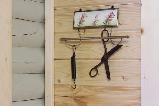 Vintage composition on the background of a wooden wall. Hanger, scissors, scales