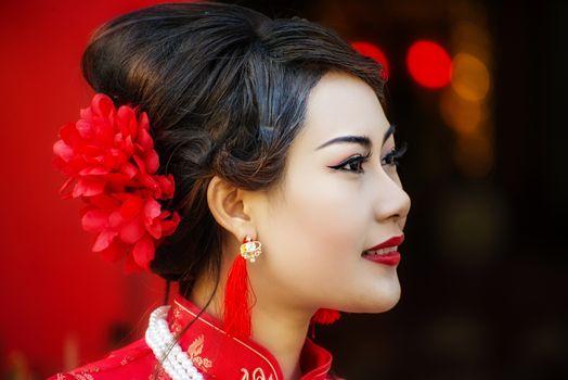 Chinese woman red dress traditional cheongsam ,close up portrait with red wood door