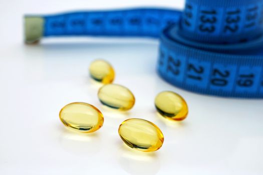 Capsules with measuring tape on white background