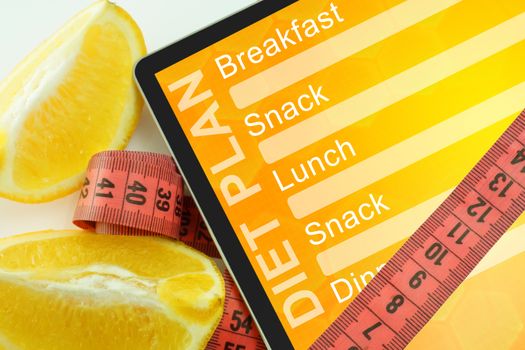 Tablet with diet plan and measuring tape on white background