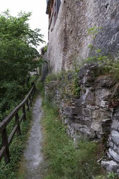 small path with wooden handrail and historic wall