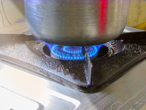 Blue Flame of gas ove when cooking is going on in an alluminium bowl.