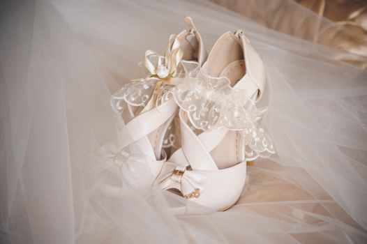 white brides wedding shoes and white garter 