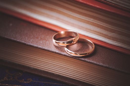 two wedding rings on top of books 