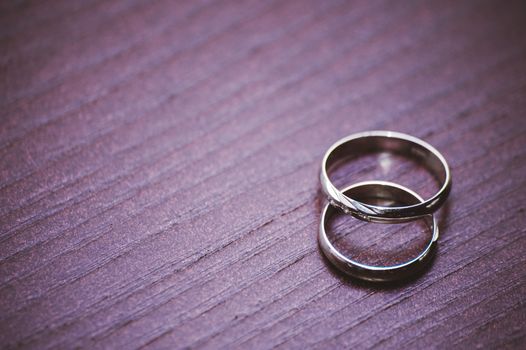 two wedding rings laying on wooden table 