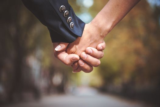 couple holding hand together in park while walking
