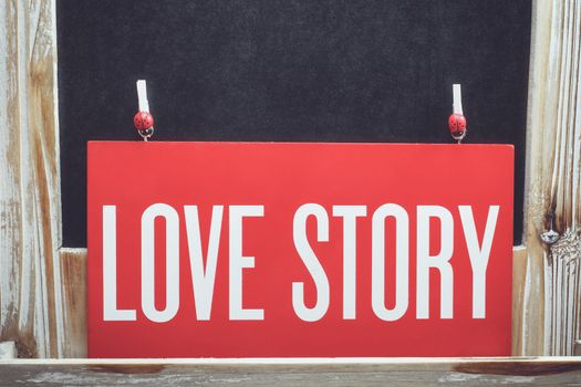 Love story words written on a board and rustic old wooden background
