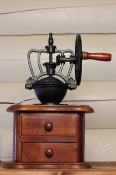 Vintage coffee grinder made of wood and black wrought metal