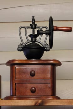 Vintage coffee grinder made of wood and black wrought metal