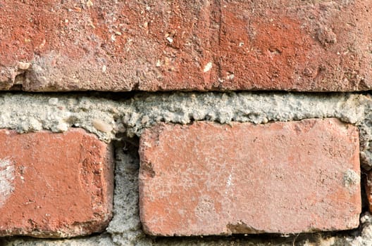 Detail of three bricks and cement wall background.