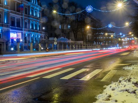 Car light in night on ice road in snow winter, Latvia