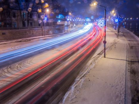 Car light in night on ice road in snow winter, Latvia