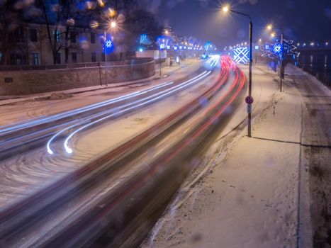 Car light in night on ice road in snow winter, Latvia