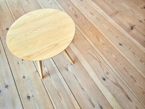 Simple round table on wooden floor. Modern design.