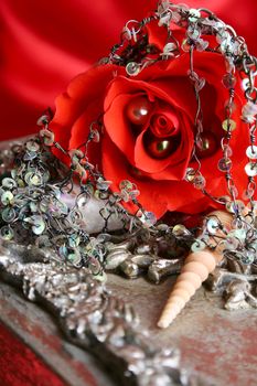 Silver gift box with a rose and seashells ontop