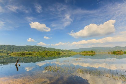 Tropical lake under blue cloudy sky in Thailand.