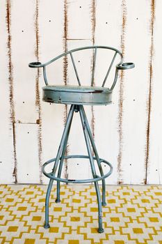 Vintage stool with white wooden background.