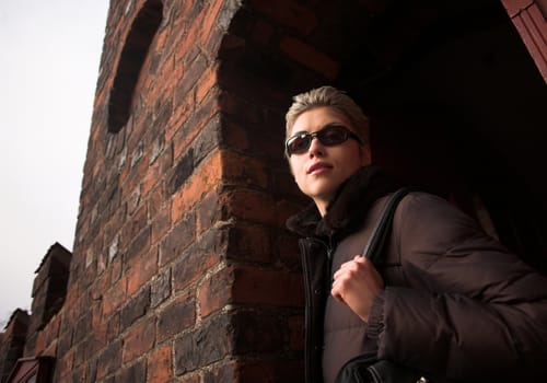 pretty woman outdoor in an old village in denmark with a
wall   in red brick 
