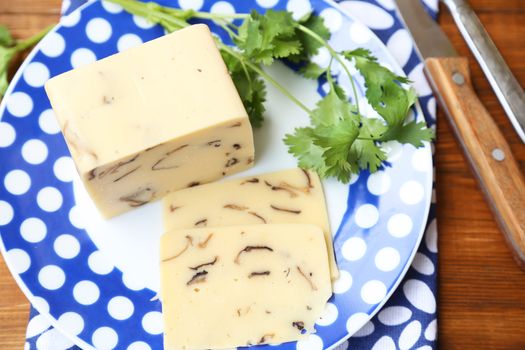 cheese with mushrooms,near the green parsley on wooden plate