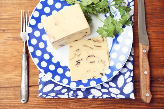 cheese with mushrooms,near the green parsley on wooden plate