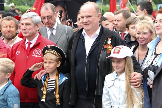 Moscow, Russia - May 9, 2012. March of communists on the Victory Day. The leader of communist party of Russia Gennady Zyuganov is photographed with children