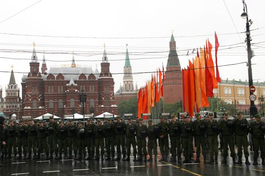 Moscow, Russia - May 9, 2012. March of communists on the Victory Day. Cordon of police and the soldier of internal troops in front of the Kremlin during procession of communists