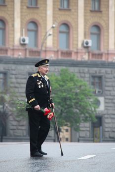 Moscow, Russia - May 9, 2012. March of communists on the Victory Day. The unknown old man the veteran of war with awards, with flowers and in a uniform, in day of procession of communists