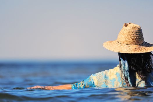 Woman with hat and wet dress in water