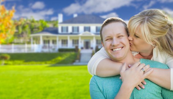 Happy Couple Hugging In Front of a Beautiful House.