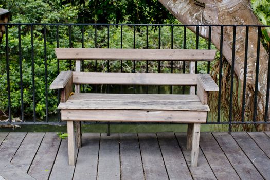 Wooden bench in terrace with green tree view