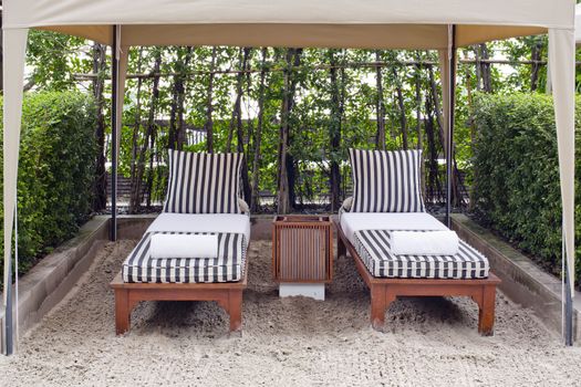 Beach chair and big umbrella on sand beach. Concept for rest, relaxation, holidays, spa, resort.