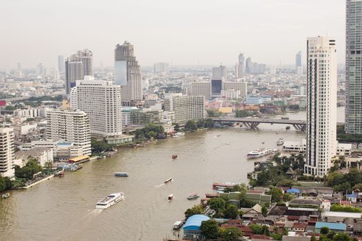 top view ship on Chao Phraya river, bridge and city scape in Bangkok, Thailand
