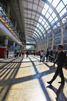 HONG KONG, S.A.R., CHINA - JENUARY 29, 2014: Passengers in the airport main lobby on Jenuary 29, 2014 in Hong Kong, China. The Hong Kong airport handles more than 70 million passengers per year.