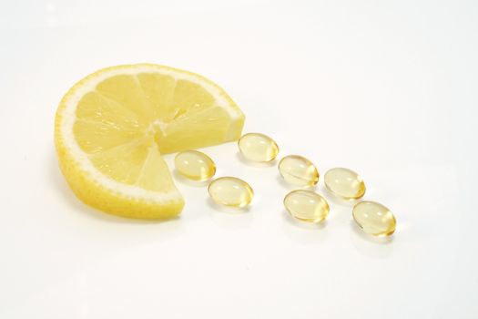 Lemon slice with yellow vitamin pills - vitamin concept
