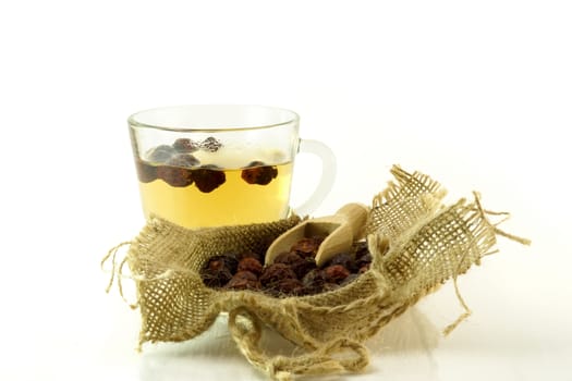 Cup of herbal tea with briar on a white background
