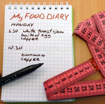 Measuring tape, a marker and a notepad with a food diary