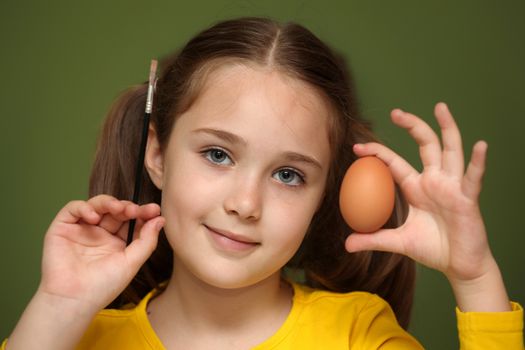 Girl painted Easter eggs at the table