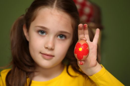 Girl painted Easter eggs at the table